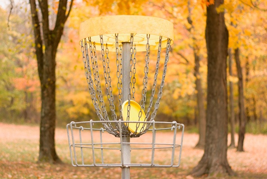 Disc golf is similar to regular golf in that the players try to throw their disc into a basket in as few throws as possible.