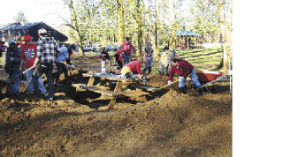 White River students pushed up their sleeves and kept digging until they found the buried picnic tables in South Prairie’s Veterans Park.