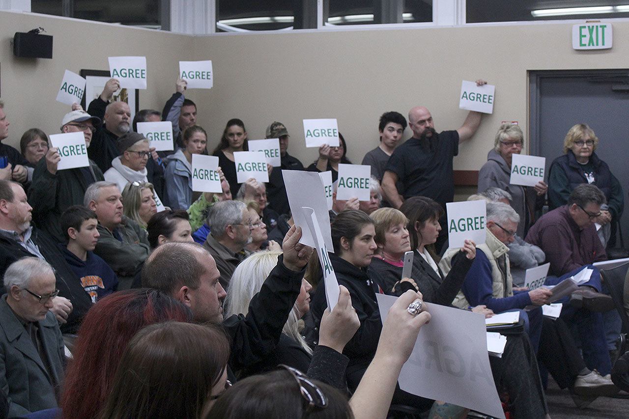 Black Diamond residents were provided with signs to indicate whether or not they agree with comments made by the city council. The majority of attendees seemed overwhelmingly in favor of the council passing Mayor Carol Benson’s budget. Photo by Ray Still