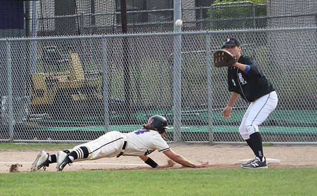 A Spartan dives back to first, racing a ball thrown toward Bonney Lake’s first baseman in a hotly contested game. Photo by Ray Still