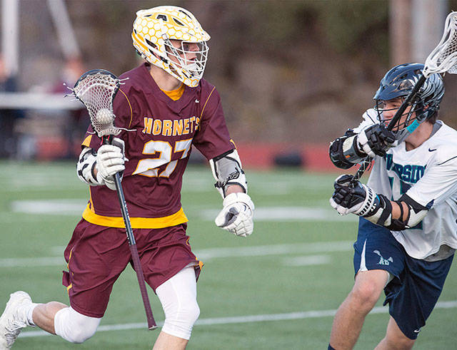 Then-senior Marcuz Henke, a captain of the Hornet Lacrosse team last year, looks to get past a defender during the 19-7 victory over Auburn Riverside. Photo by Vince Miller.