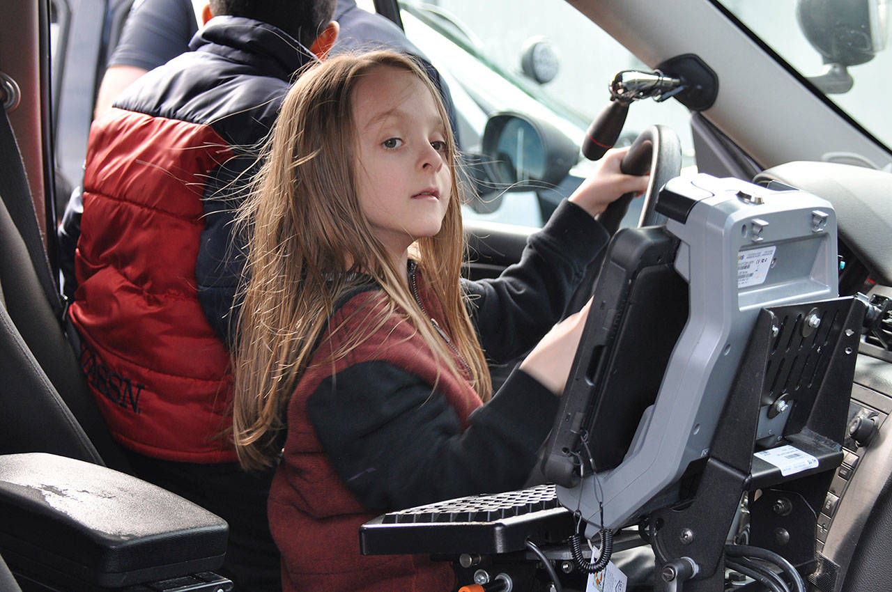 Caden Smith, a first-grader at Daniel Elementary, pretends to drive a police car. Photo by Heidi Sander.