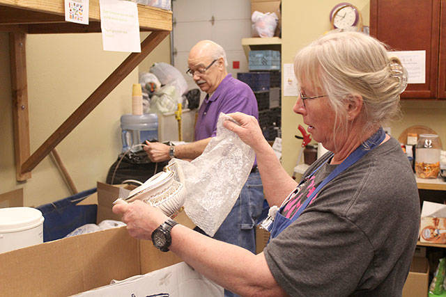 Dede Trowbridge and Mike Gordon go through donations at the Pennies from Heaven thrift store, run by Plateau Outreach Ministries. POM promotes volunteer opportunities through the Justserve.org website. Photo by Ray Still