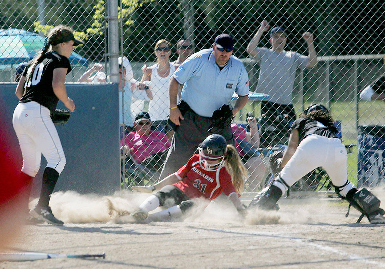 A controversial play at the plate decided the district championship. Here, the umpire rules that Yelm’s Ally Choate beats the tag of Bonney Lake catcher Hailee Hagins. Photo by Dennis Box.