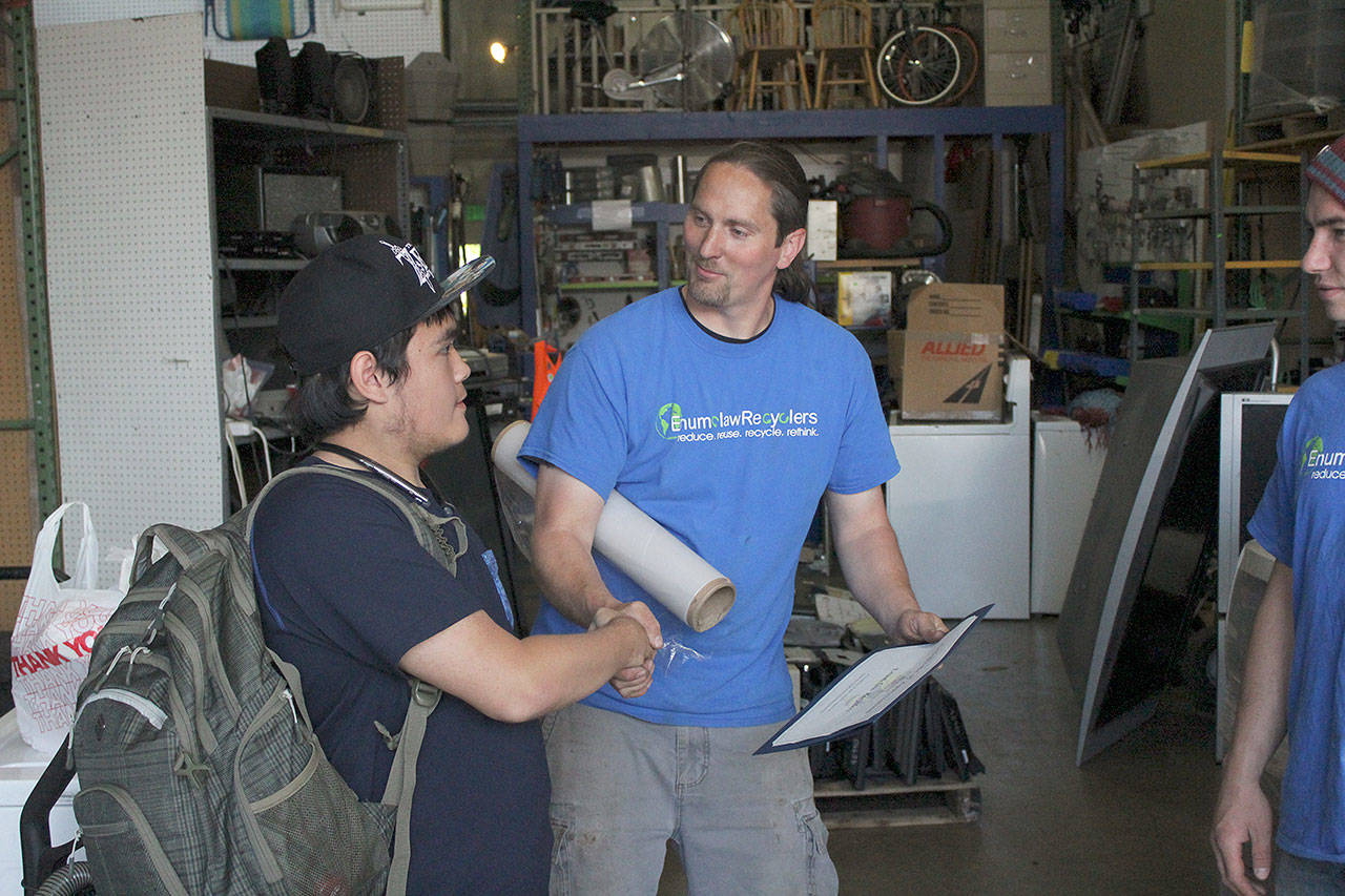 EHS student Joseph Landon thanks Jesse Streck for working with him at Enumclaw Recyclers. Photo by Ray Still