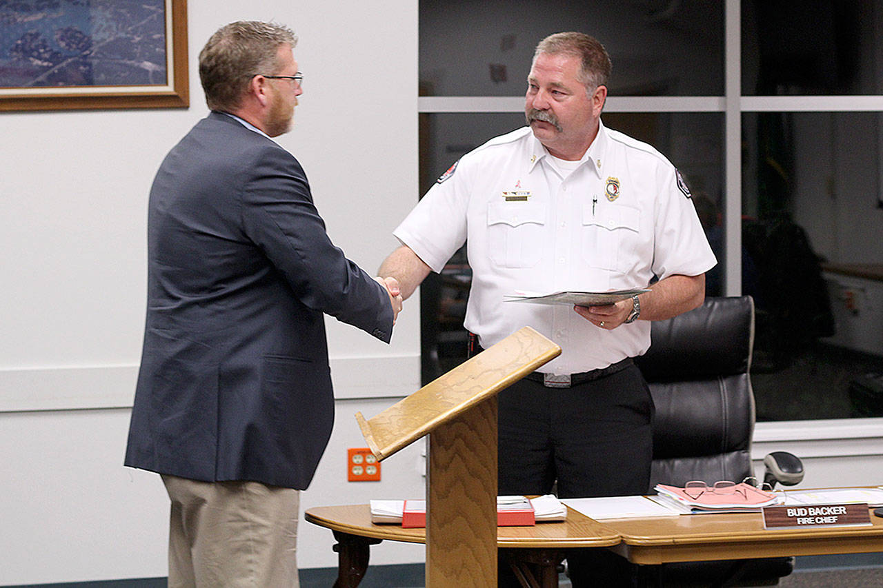 Senior Vice President of developer American Newland Communities Scott Jones gives East Pierce Fire and Rescue Chief Bud Backer the deed to a 3.3-acre plot of land for a new fire station in the Tehaleh development. Photo by Ray Still.