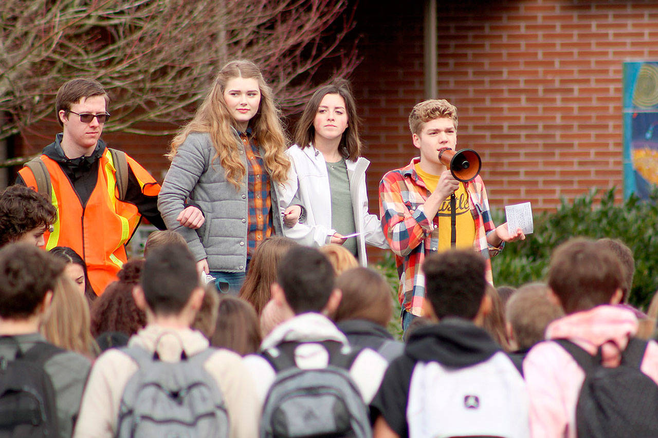 Briley Conant, second from the left, and Zach Pederson, far right, ask other Sumner high schoolers to link arms in a show of unity and support for each other, and other students around the nation. Photo by Ray Still