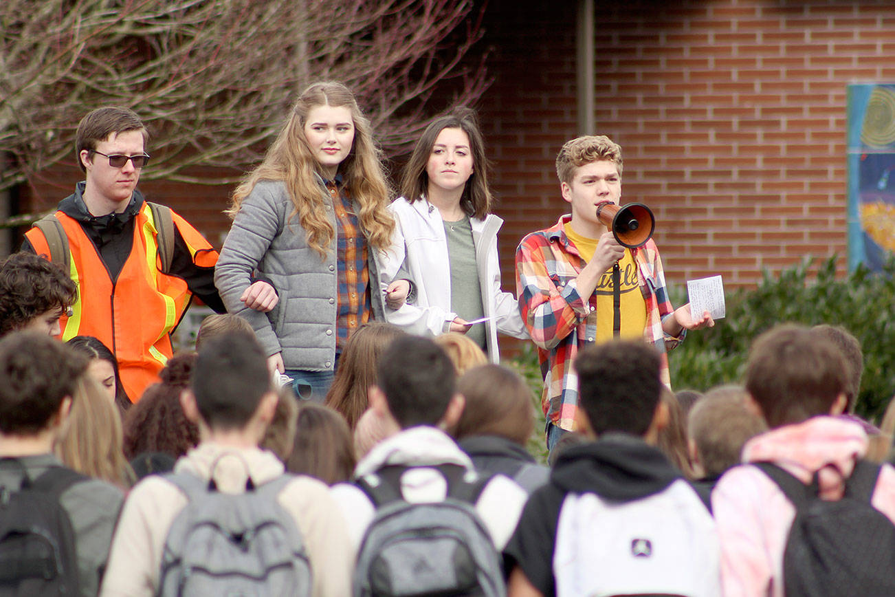 Briley Conant, second from the left, and Zach Pederson, far right, ask other Sumner high schoolers to link arms in a show of unity and support for each other and other students around the nation. Photo by Ray Still