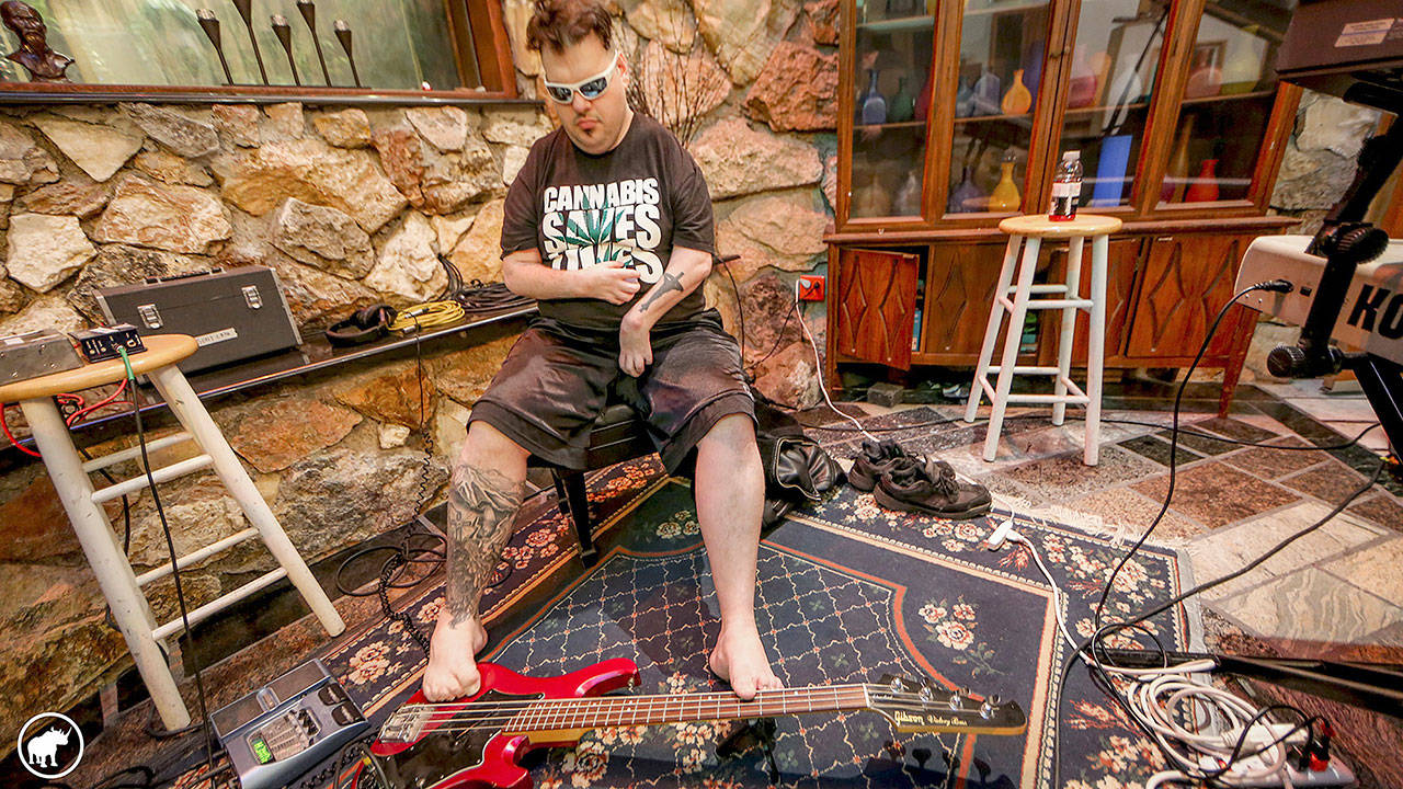 Without the use of his hands, Tim-Me has learned to use his feet for many daily tasks, including writing, typing, using a lighter and even playing the bass. Photo by Robert Lang/Robert Lang Studios