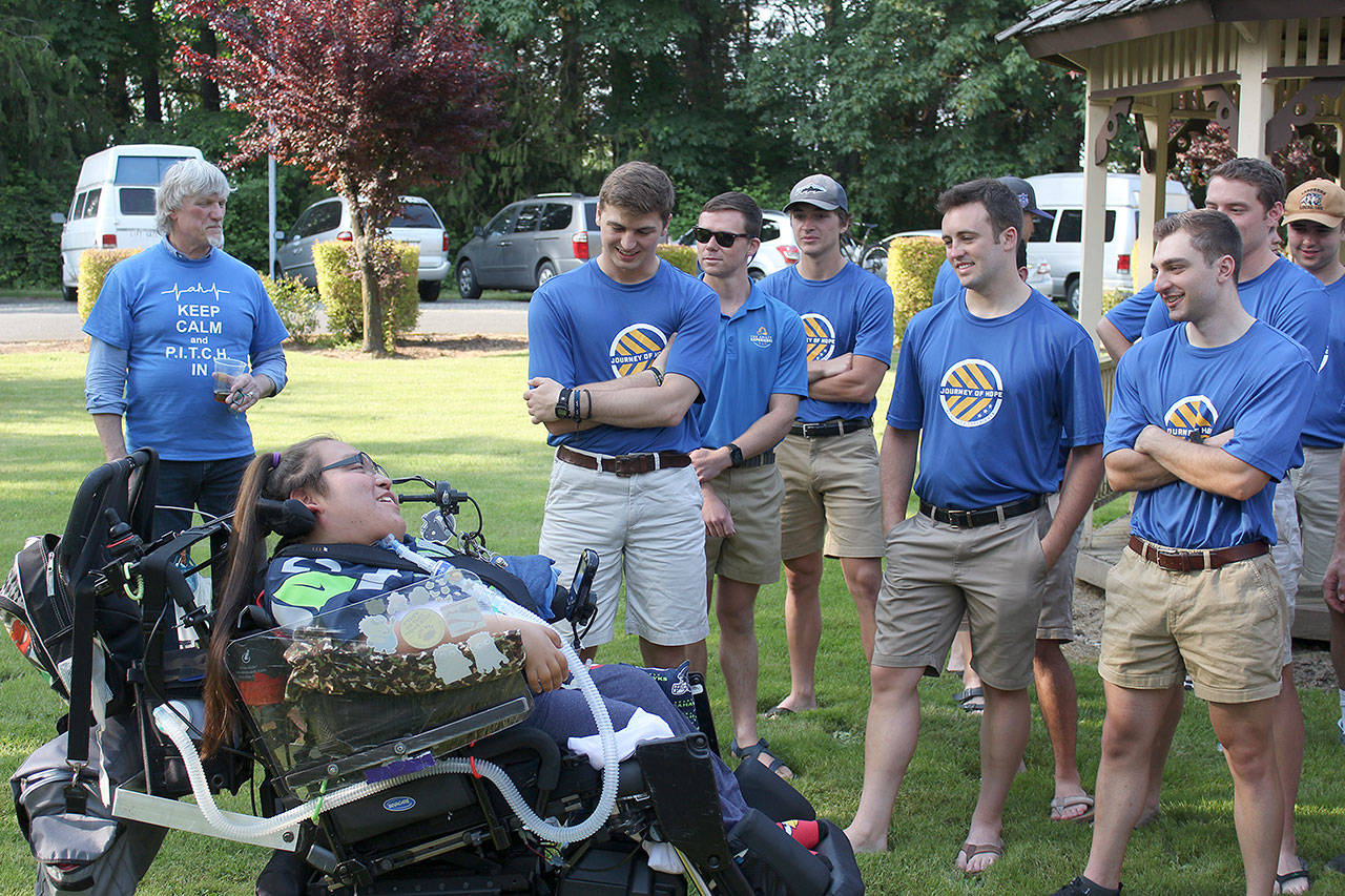Members of the TransAmerica team are greeted by Gilbert, 18, who has welcomed the cycling team to Enumclaw’s Ashley House for the last seven years. Ray Miller-Still photo.