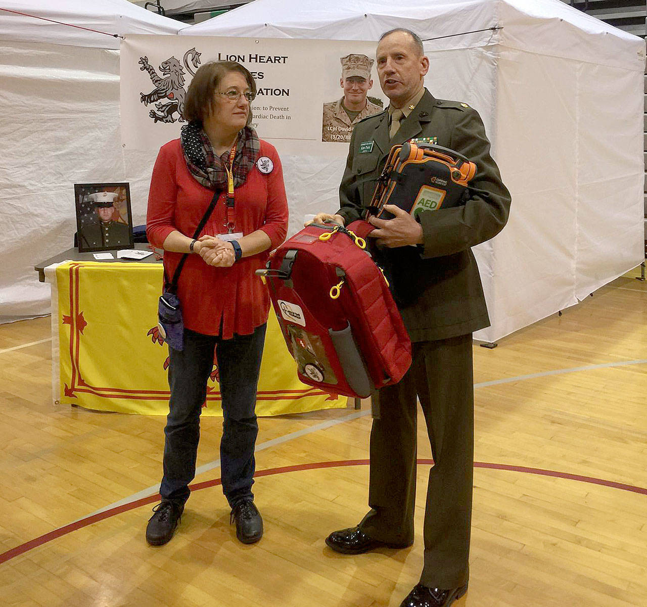 Laurie Finlayson donated an AED with a portable backpack to Major Ken Paul, the JROTC instructor at Kentwood High School in March 2017. The Nick of Time Foundation also screened 293 students at this event, and found three people with heart issues that needed follow-up care. Submitted photo.