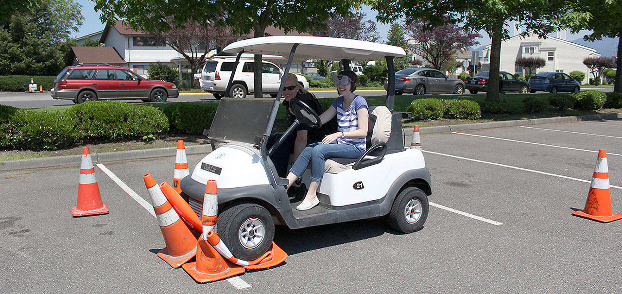 The Enumclaw and Black Diamond Police Departments helped teach all 222 Enumclaw High School seniors the dangers of driving impaired. Students tried to navigate an obstacle course of traffic cones in a golf cart while wearing goggles that simulated being drunk or high on marijuana, or had to dry and complete the course while having a live texting discussion with a friend on the sidelines. At the end of the event, Courier-Herald intern Tiani Grosso took a shot at the course. Photo by Ray Still