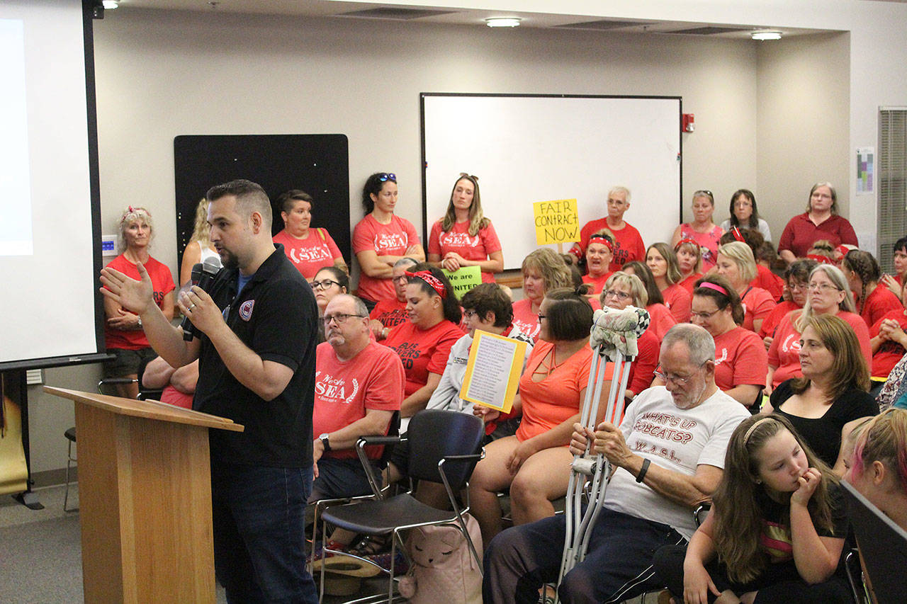 Jim Payette, at the podium, was joined by dozens of teachers, classified staff members, and community members of the Sumner-Bonney Lake School District on Aug. 15, who all packed the school board meeting to advocate for pay raises. Photo by Ray Miller-Still