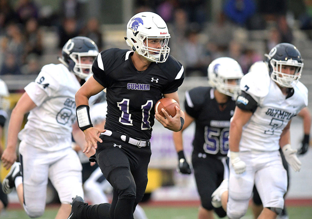 Sumner High quarterback Austin Grondahl picks up yardage during last week’s rout of visiting Olympia. Photo by Vince Miller/www.vincemillerphoto.com