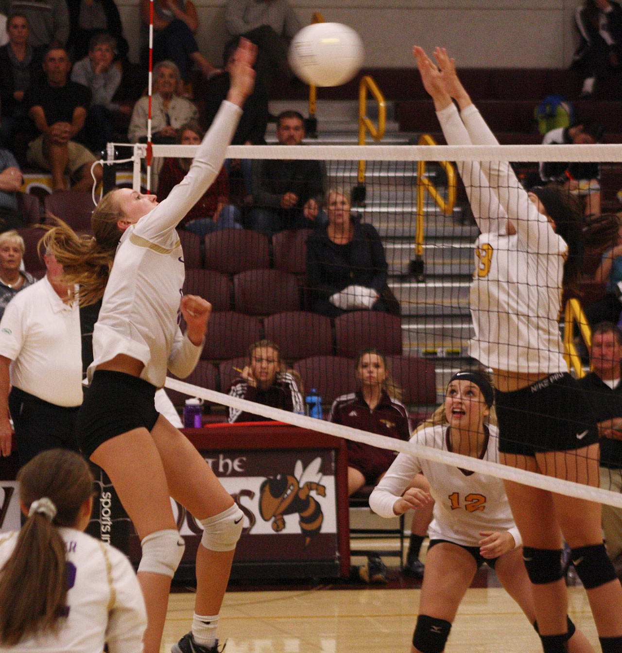 Sumner sophomore Jordyn Manning goes for the kill, while Hornet Lauren Hanson attempts to block. Photo by Kevin Hanson