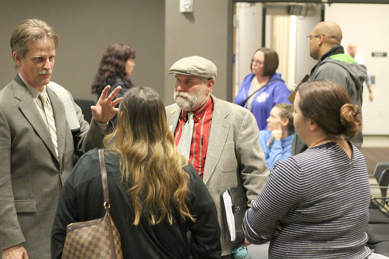 Bonney Lake residents concerned with the rising water and sewer rates in their city talk to Councilmen Dan Swatman, left, and Tom Watson, right, as well as the city’s Finance Director Cherie Gibson, back left, after the Nov. 13 council meeting. Photo by Ray Miller-Still