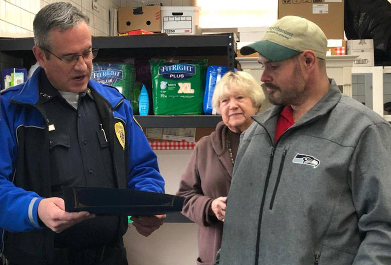 Sumner Police Chief Brad Moericke gives Kevin Booth a citizens citation for giving $17,000 to the Sumner Food Bank. Submitted photo