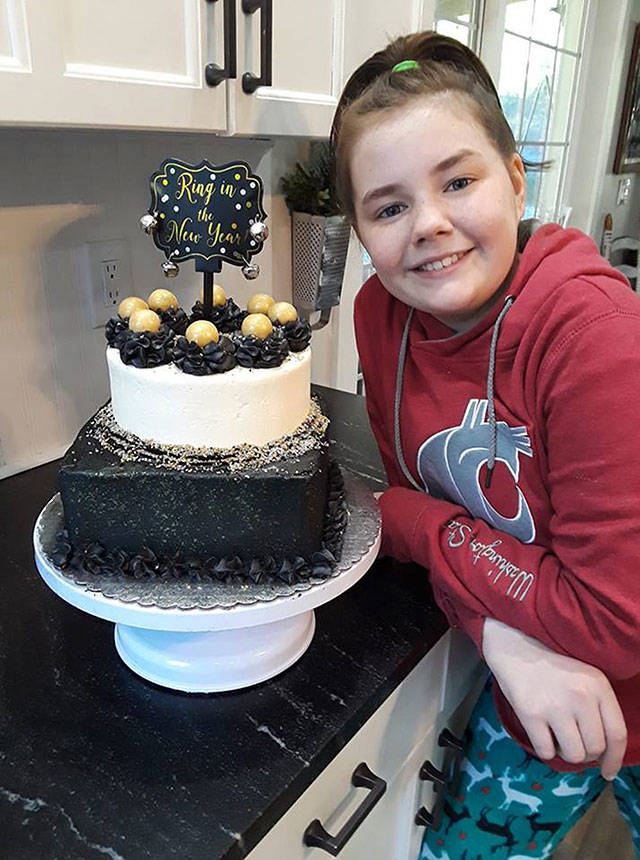 Micah Crawford, 12, shows off a New Years cake she made for a customer, complete with a chocolate square base with chocolate buttercream and a vanilla top with strawberry buttercream filling. Image courtesy Cory Crawford