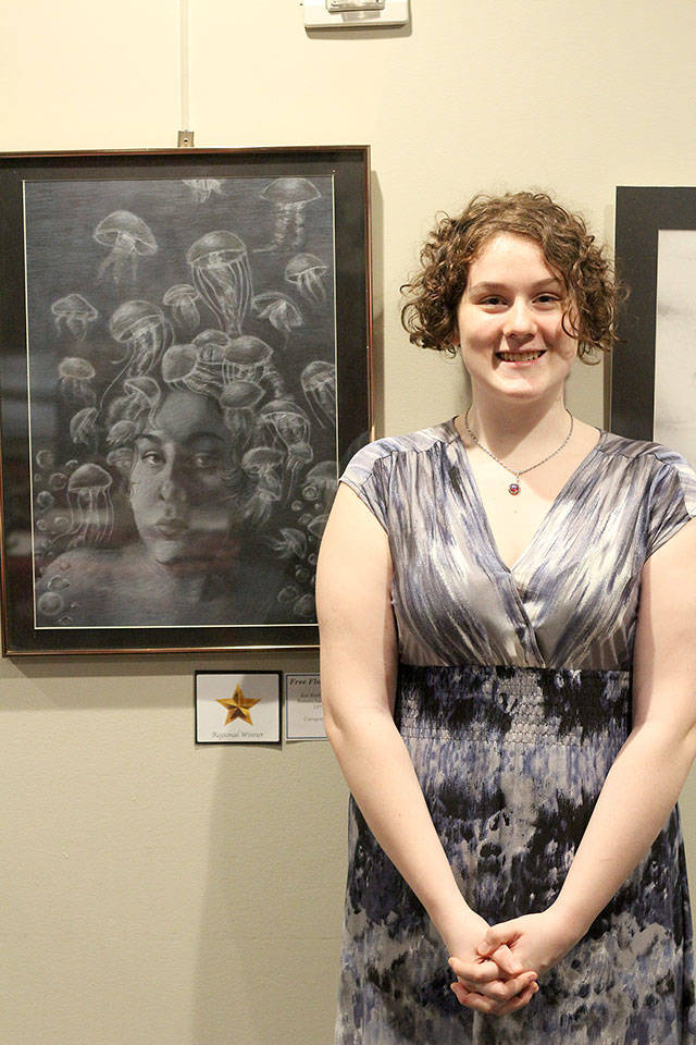 Zoe Asquith, a Bonney Lake High School Senior, stands next to her charcoal drawing, “Free-flowing Mind,” which was one of the finalists in the Puget Sound Education Service District’s annual art competition. Photo by Ray Miller-Still