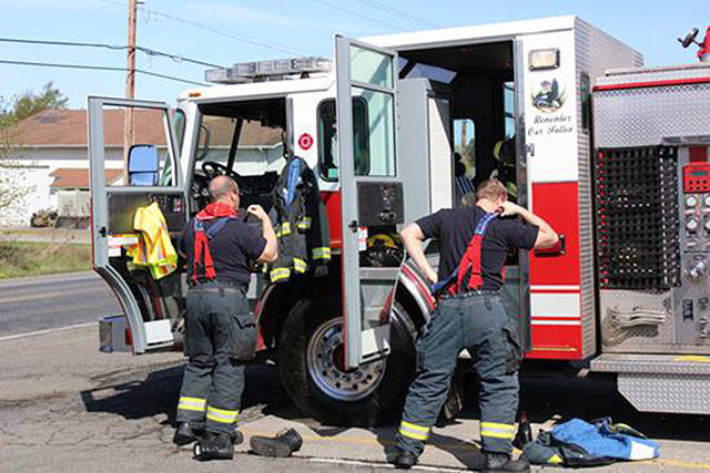 East Pierce Fire and Rescue firefighters gear up for an alarm during an open house event. File photo by Ray Miller-Still