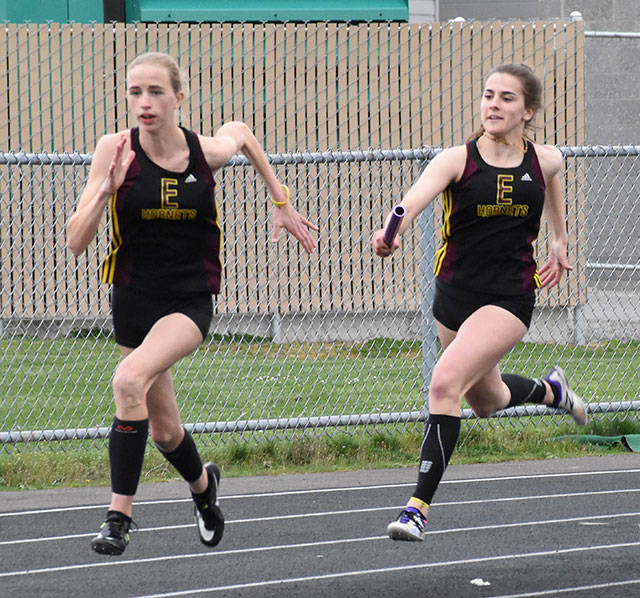 Gracie Neu, holding the baton, and Johanna Brown make up one-half of Enumclaw High’s state-leading 4x400 relay team. File photo by Kevin Hanson