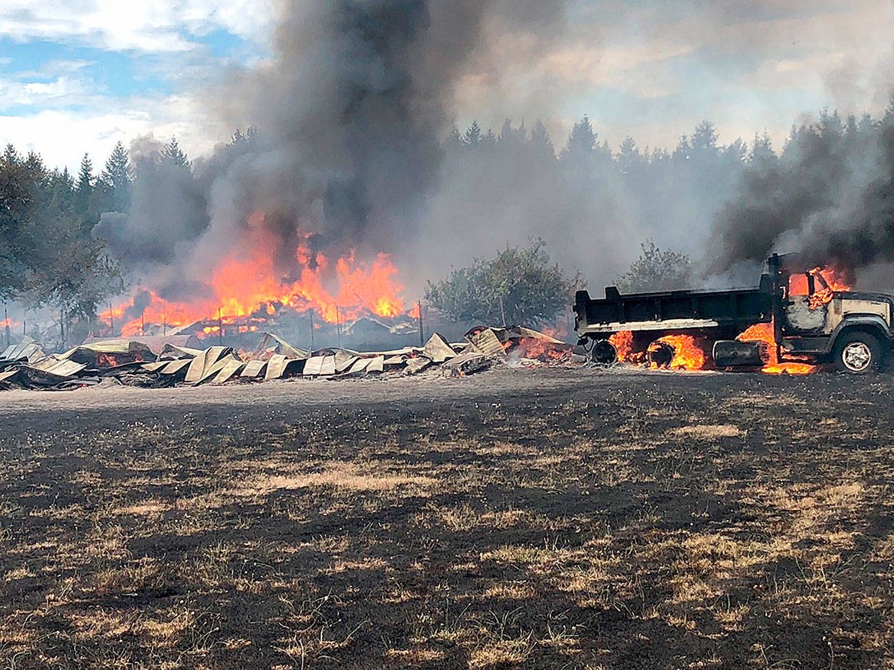A brush fire in Buckley last summer destroyed two barns, a mobile home, two cars, a dump truck, a panel truck, and other buildings and vehicles. Photo courtesy East Pierce Fire and Rescue