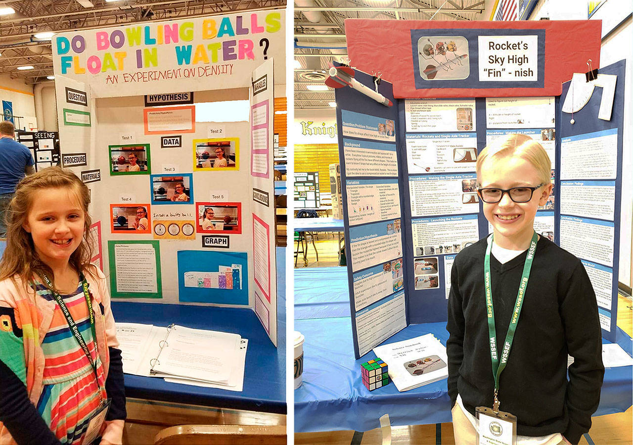 Bridgette Lowe, left, and Garrison Stephens-Smith, right, pose with their science fair presentations during the annual Washington State Science and Engineering Fair (WSSEF), which was held at the end of last March. Submitted photos