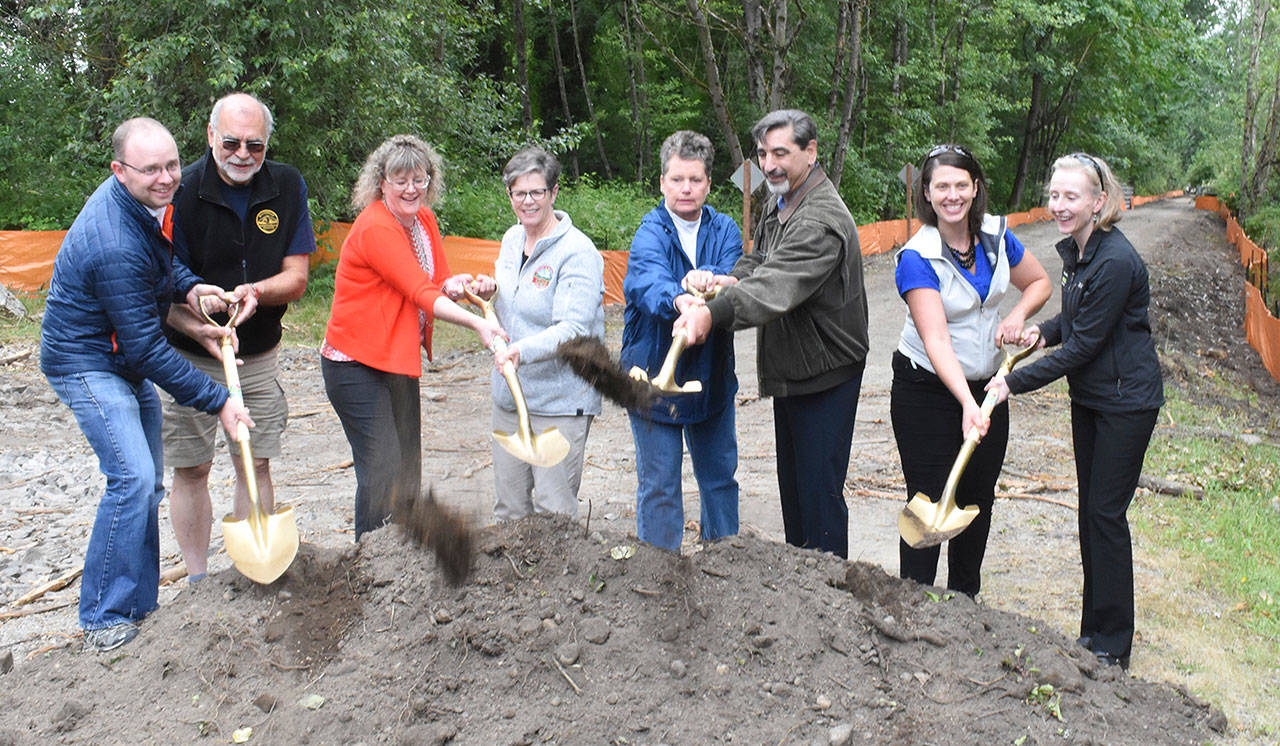 Taking part in the ceremonial groundbreaking June 19 were, from left: State Rep. Morgan Irwin, Foothills Rails To Trails President Stuart Scheuerman, Pierce County Parks and Recreation Director Roxanne Miles, Buckley Mayor Pat Johnson, former Enumclaw Mayor Liz Reynolds, current Enumclaw Mayor Jan Molinaro, Christine Mahler of the Washington Wildlife and Recreation Coalition and Katy Terry, acting director for King County Parks. Photo by Kevin Hanson