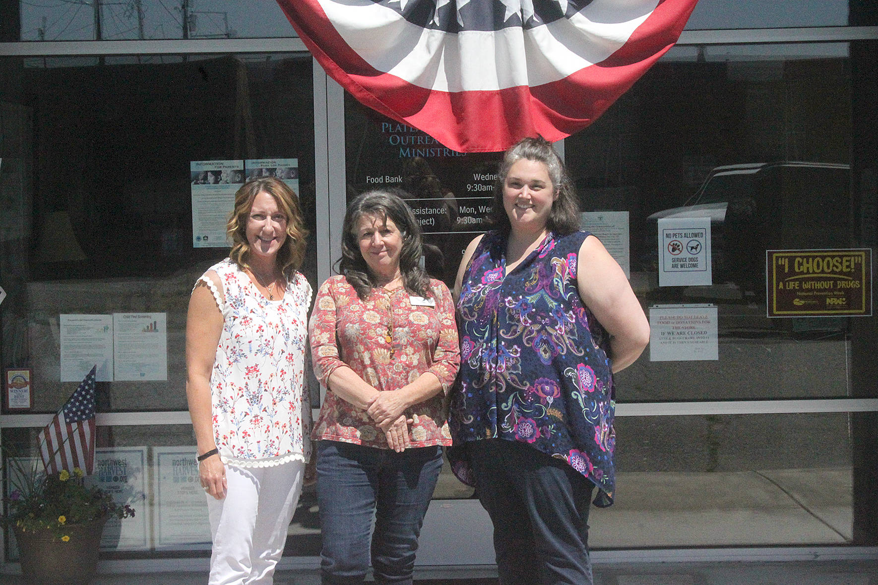 From left to right: Plateau Outreach Ministries Director Elaine Olson, Outreach Case Manager for Veterans and Seniors Lisa Napolitano, and Director Elisha Smith-Marshall stand outside of their nonprofits office. The trio work together regularly to help lift up the vulnerable populations in Enumclaw, Black Diamond and Covington.                                Photo by Danielle Chastaine