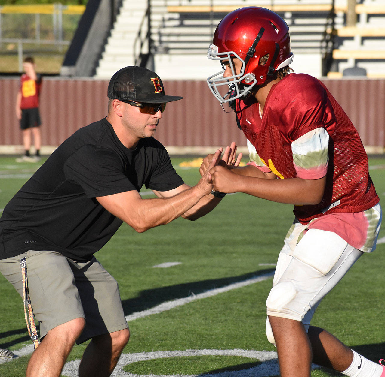 Coach Mark Gunderson works on technique with one of his players during an Aug. 28 practice. Photo by Kevin Hanson