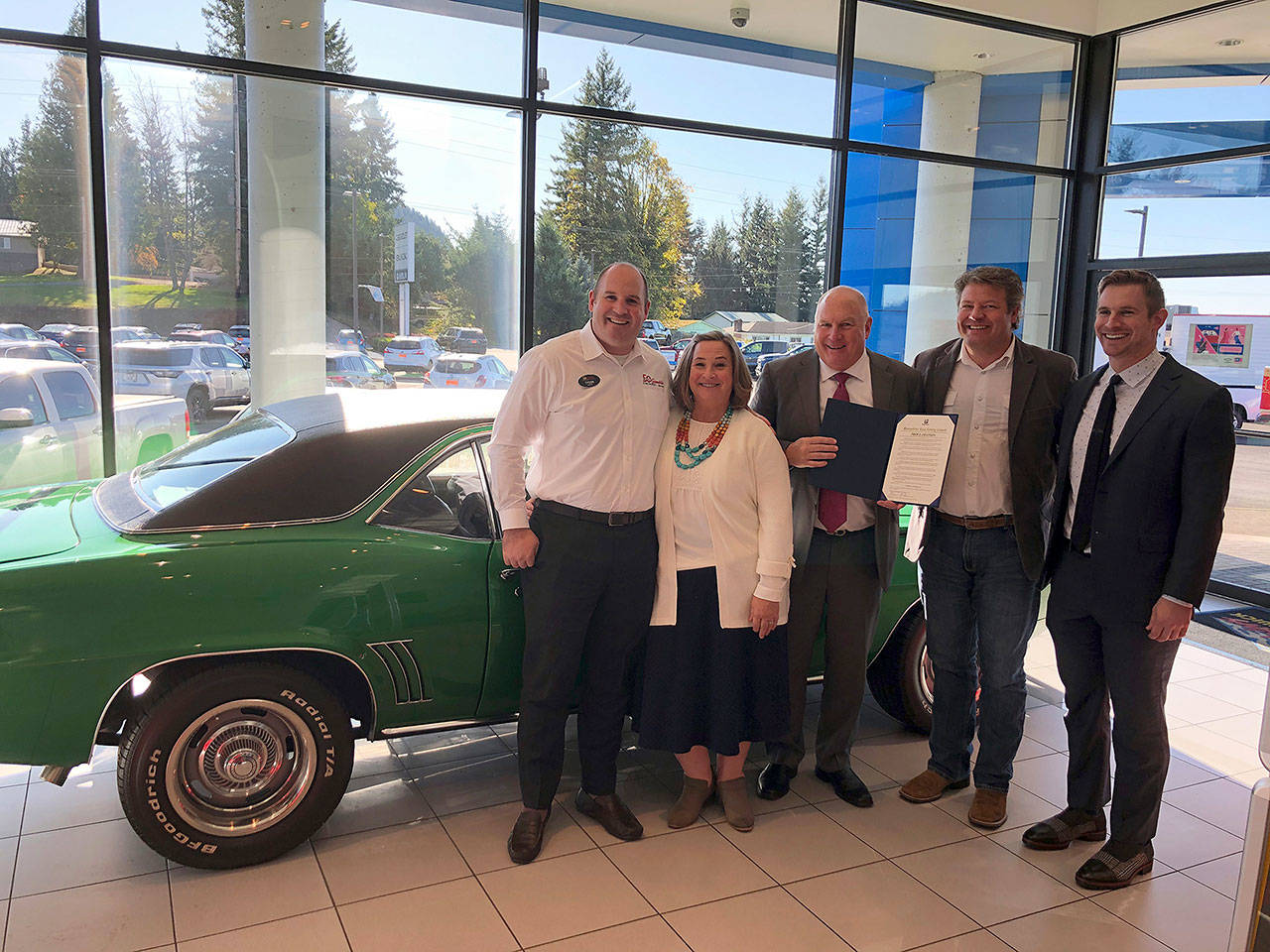 Alan Gamblin, center, with Jeri Gamblin and son Tyson, to the left and King County Councilmember Reagan Dunn to the right, standing in front of a 1969 Camero in commemoration of when the Gamblin dealership came to Enumclaw. Contributed photo