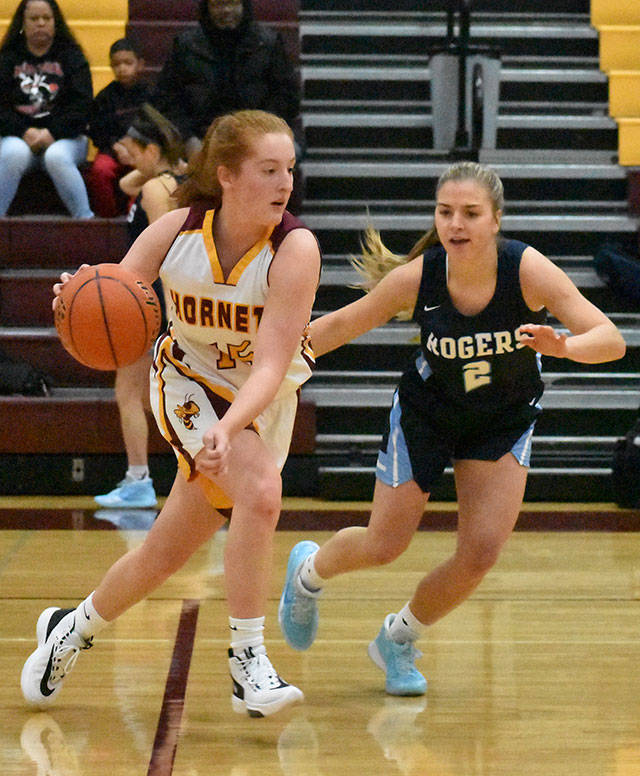 The basketball season tipped off Saturday at White River High with a four-team jamboree. Above. the Hornets’ Kara Marecle races past a Rogers High defender. Photo by Kevin Hanson