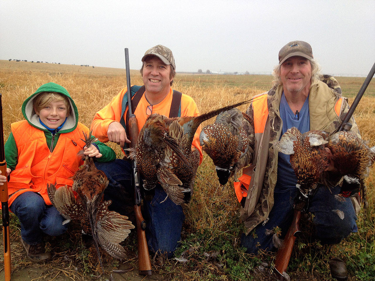 Arlin Anderson, Eric Anderson, and Jim Ritter hold up some pheasants they hunted; the birds will be served at the Wild Game Feed. Contributed photo