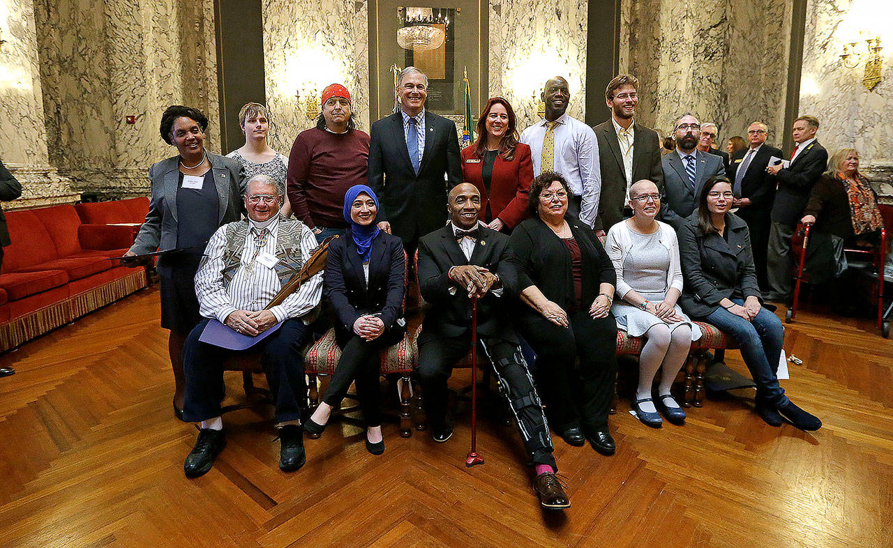 Democratic electors and state officials pose for a photo after a meeting of the state’s Electoral College in December 2016. Seated, from left, are Dan Carpita, Varisha Khan, Phillip Tyler, Julie Johnson, Elizabeth Caldwell and Levi Guerra. Standing, from left, are Esther John, Ryleigh Ivey, Robert Satiacum, Gov. Jay Inslee, Secretary of State Kim Wyman, Chris Porter, Eric Herde and Bret Chiafalo. Chiafalo, of Everett, along with John and Guerra did not cast their votes in the Electoral College for Democratic candidate Hillary Clinton, who won the state’s popular vote. (AP Photo/Elaine Thompson, file)