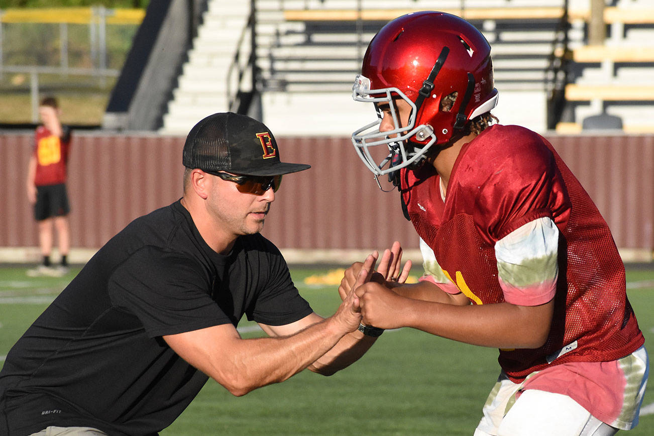 Athletes, coaches, parents and fans throughout the state are waiting for news about the start of the fall athletic season. Once gatherings are permitted, coaches will be able to work with players (like in this photo with Enumclaw football coach Mark Gunderson teaching technique) and players can hit the field. File photo by Kevin Hanson