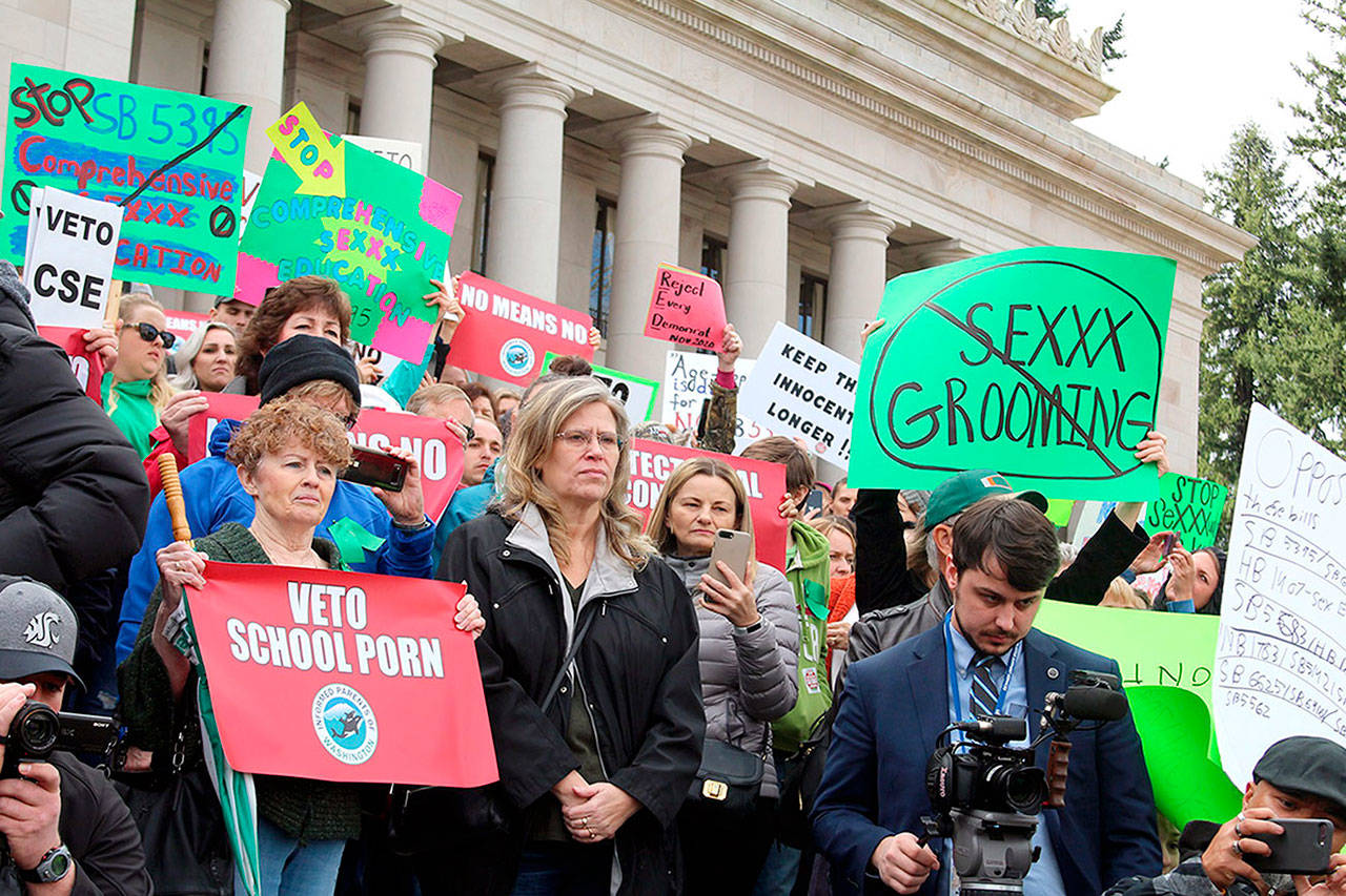 Dissatisfied residents hold signs in protest of comprehensive sex education mandate. Cameron Sheppard/ WNPA News Service