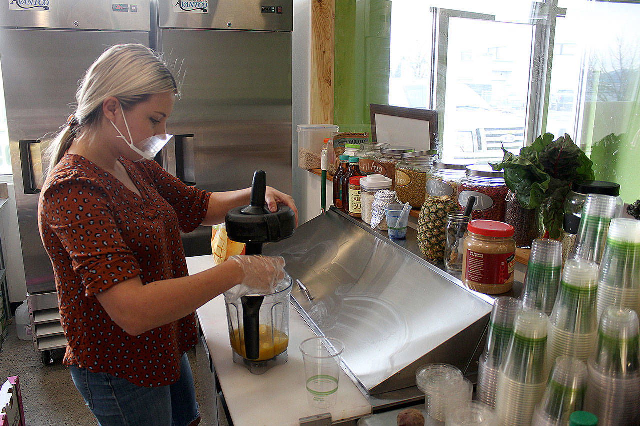 Health Bar owner Heidi Hawkinson preparing a mango smoothie. Photo by Ray Miller-Still