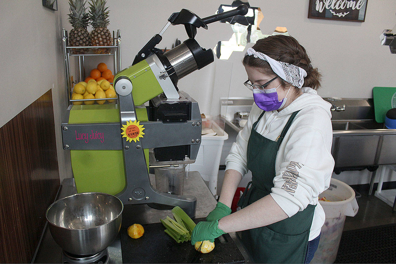 Corrine Hennessy getting ready to load up their cold-press juicer, Lucy Juicy. Photo by Ray Miller-Still