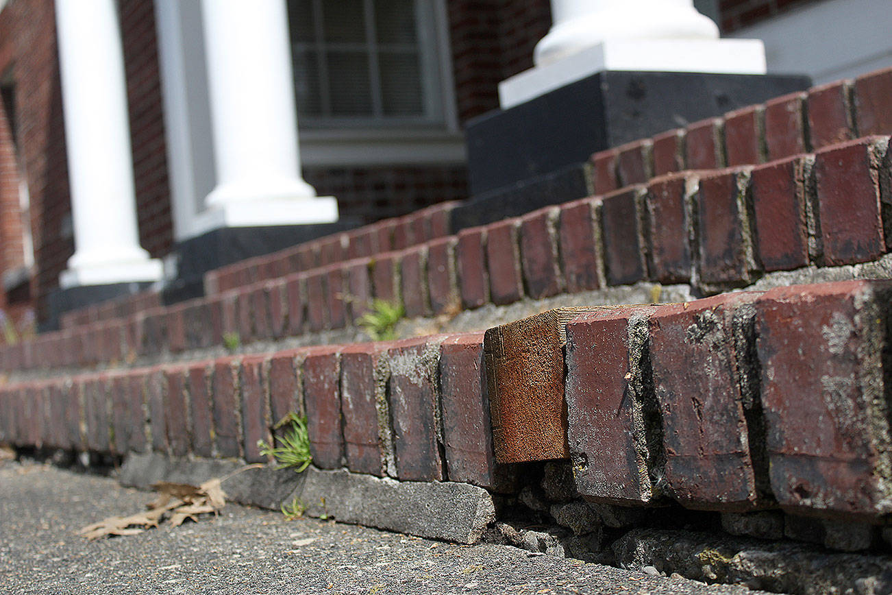 Enumclaw's City Hall's front steps are in desperate need of repair; some of the paver bricks, like you see here, have simply been replaced with wooden blocks. Photo by Ray Miller-Still