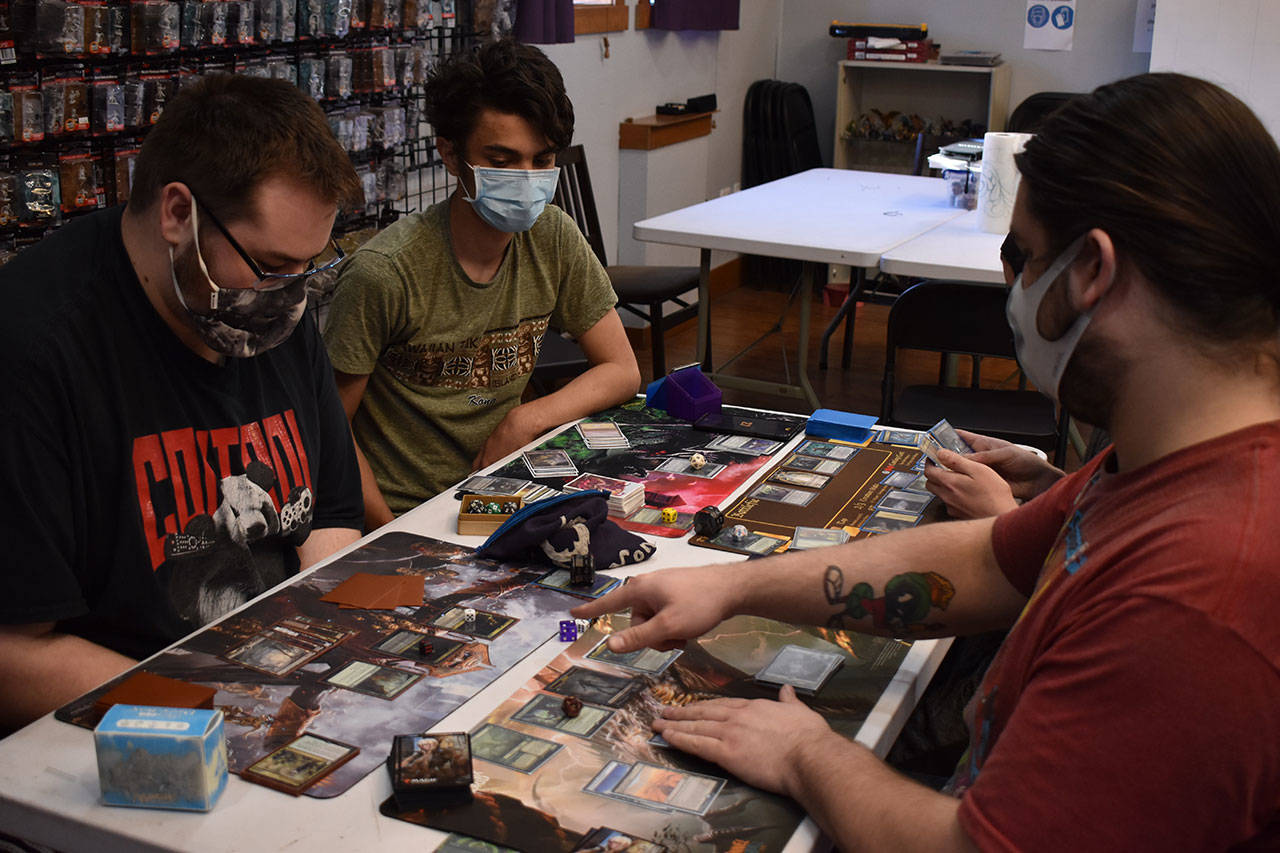A group of gamers plays Magic: The Gathering at Rock Paper Games. Photo by Alex Bruell