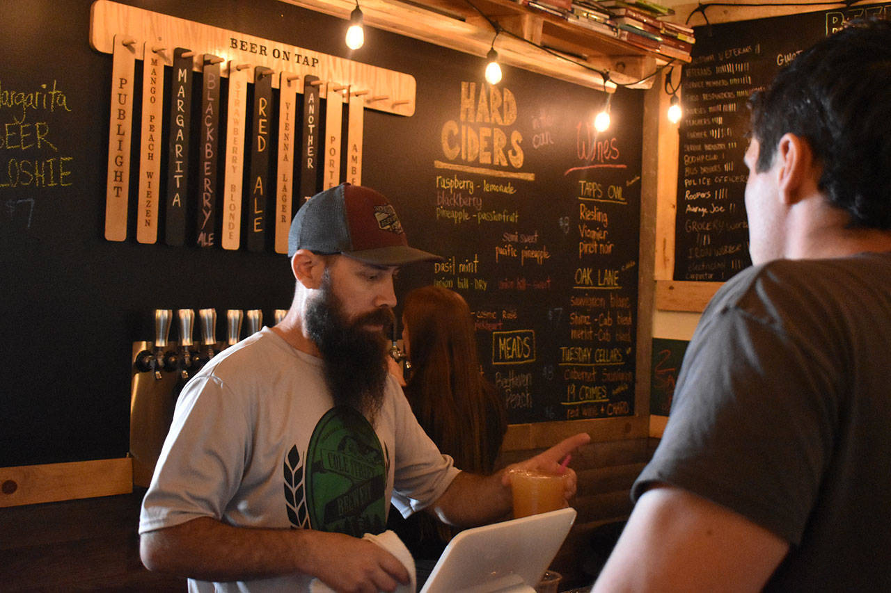 Sean McDonald, owner, and Sam Smith, beertender, serve drinks on a busy Friday afternoon at Cole Street Brewery. Photo by Alex Bruell