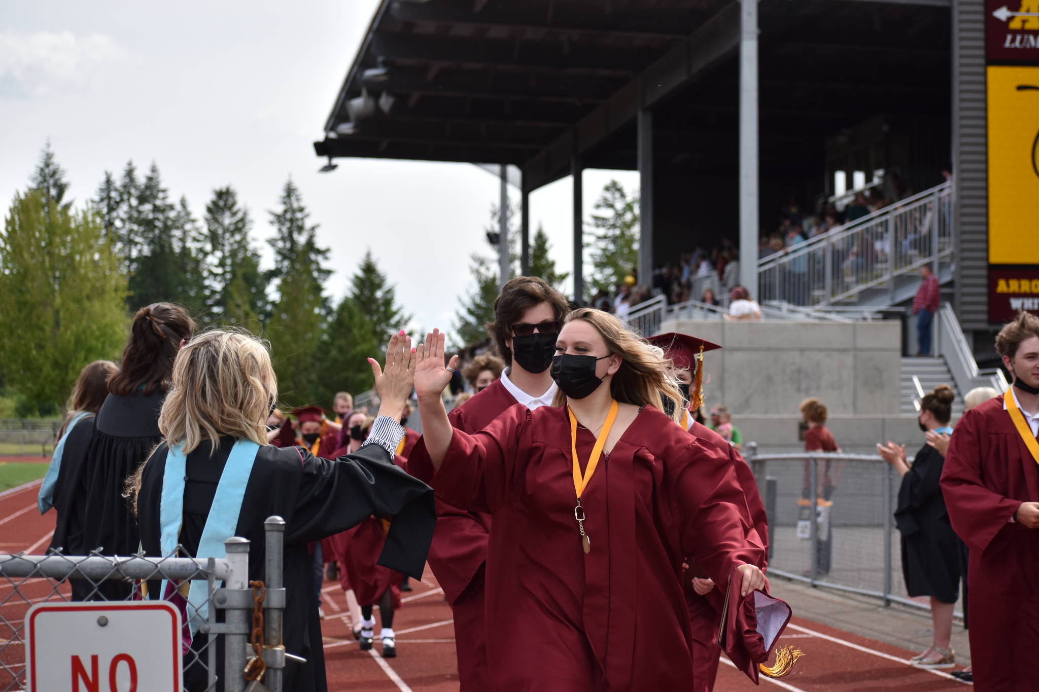 A student and staff share a high-five at the close of the WRHS graduation ceremony. Photo by Alex Bruell