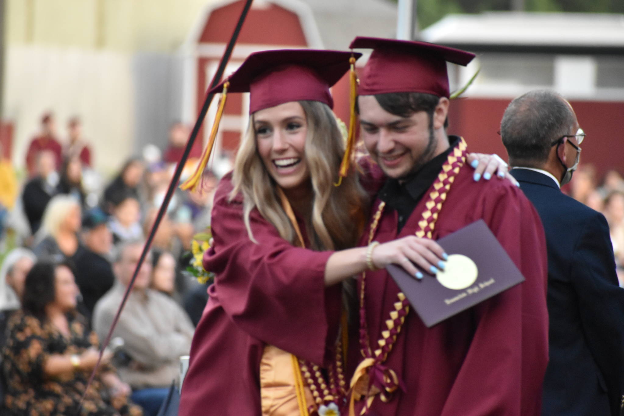 Photo by Alex Bruell 
Two students share a happy moment as they walk off the stage at graduation.