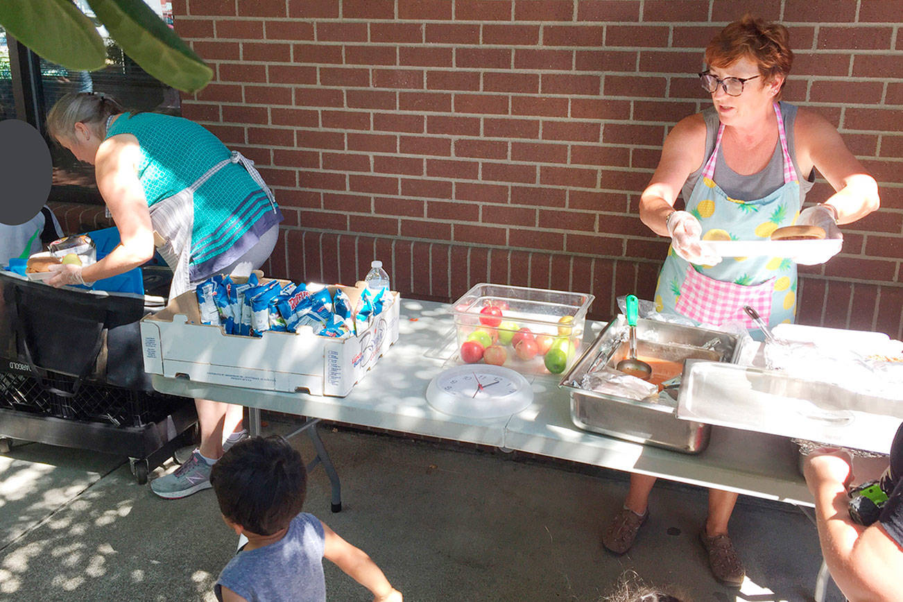 Summer Food Program workers prepare to serve from a site at the Enumclaw library in summer 2018. Enumclaw High School, Byron Kibler Elementary School and Black Diamond Elementary will be the distribution points instead in 2021. Photo courtesy Enumclaw School District.