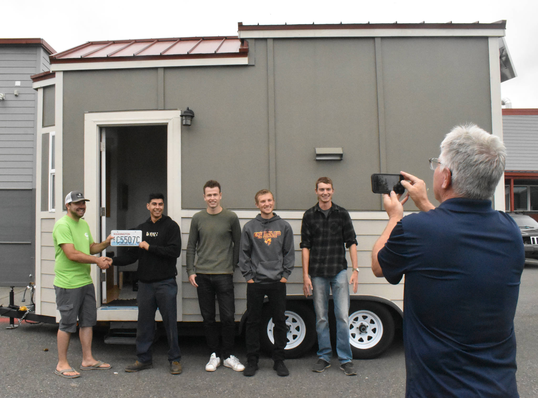 PHOTO BY KEVIN HANSON 
Former EHS teacher Bob Kilmer snaps a photo of the tiny house his students created. The home will now used by those advocating for small-home living. Some of the students involved in the project gathered Friday with Todd McKellips (left), director of the Washington Tiny House Association.