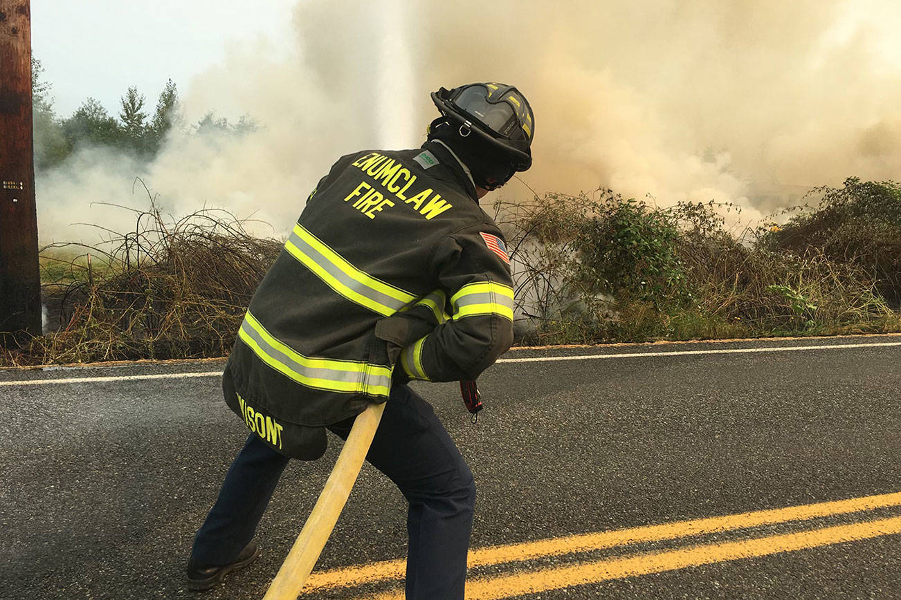 Volunteer firefighter Tristan Wisont works at putting out flames from the brush fires caused by downed power lines near Enumclaw Thursday, Aug. 5. Photo courtesy Enumclaw Fire Chief Randy Fehr.