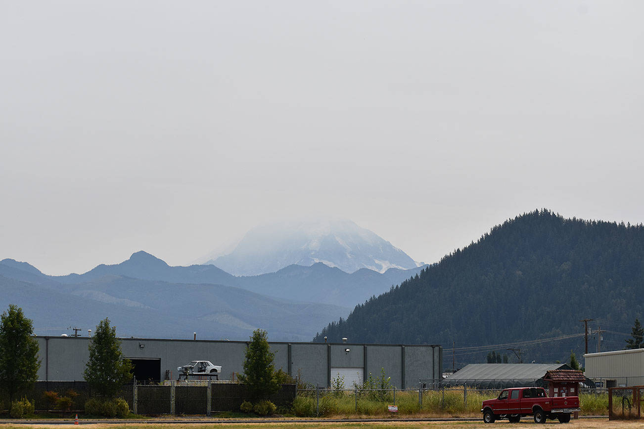 Fog, and possibly a touch of wildfire smoke, obscure Mount Rainier behind Mount Peak in downtown Enumclaw on Thursday, Aug. 5. Photo by Alex Bruell