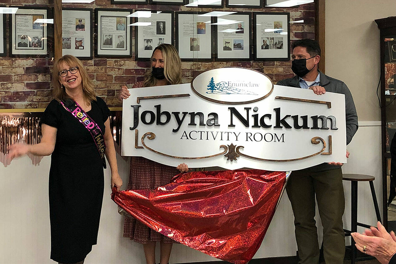 Photo by Alex Bruell 
City Administrator Chris Searcy (right) and incoming Senior Center Manager Melissa Holt (center) present the plaque that will adorn the Enumclaw Senior Center’s activity room, now named the Jobyna Nickum Activity Room. Nickum stands to the left.