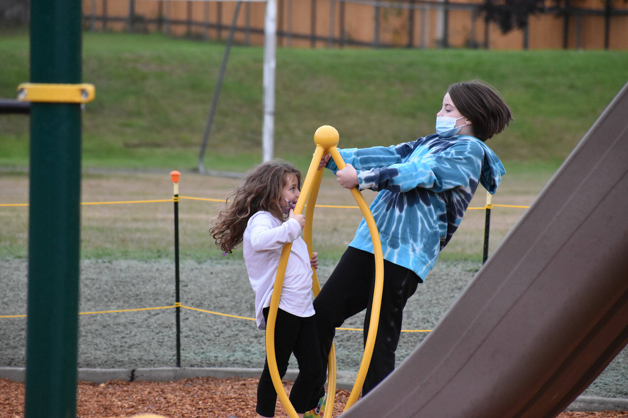 Lilli, 6 and Charlie, 10 play on the new playground at Foothills Elementary.