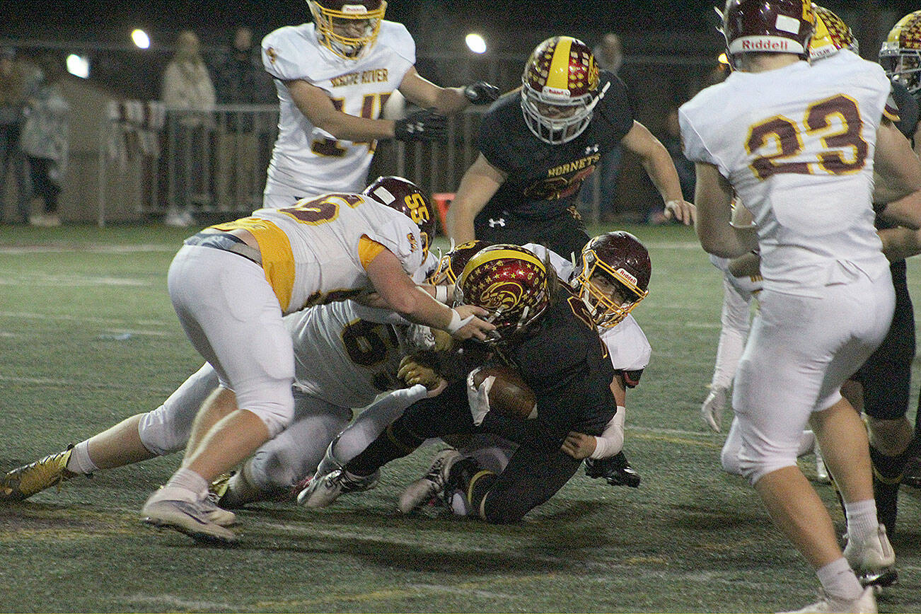 An Enumclaw Hornet is taken down by a trio of White River players. Photo by Ray Miller-Still